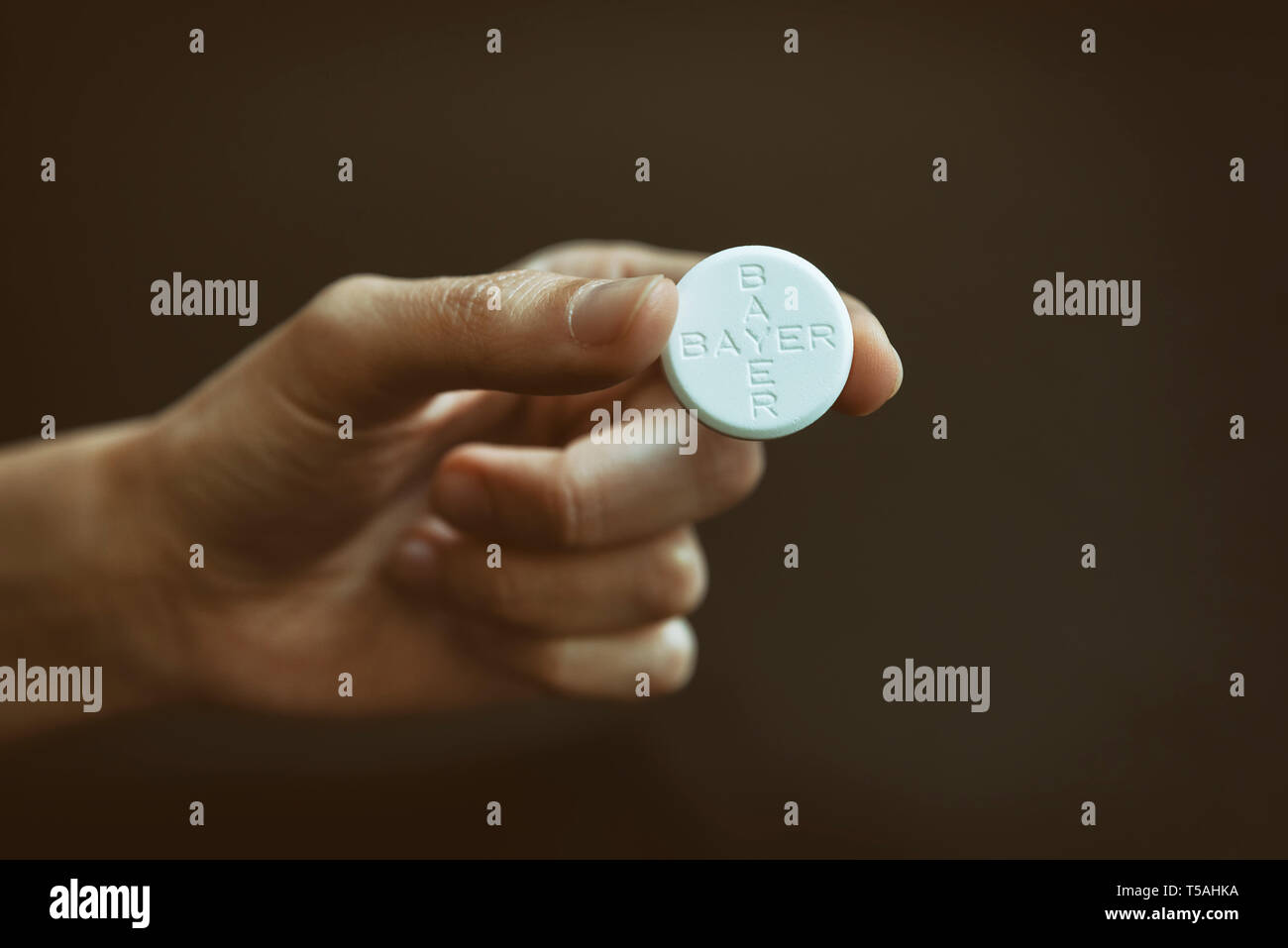 Mano femenina sosteniendo las tabletas de aspirina, conocido como ácido acetilsalicílico (AAS) es un medicamento utilizado para tratar el dolor, fiebre e inflamación. Foto de stock