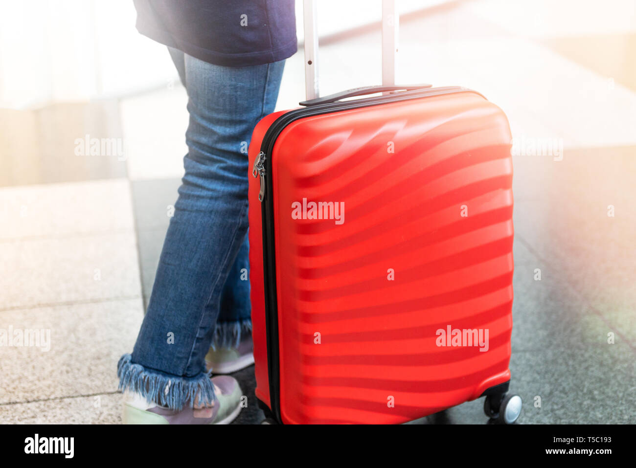 Chica está en el aeropuerto con el tamaño de la cabina luminoso y elegante  maletín como concepto de vacaciones Fotografía de stock - Alamy