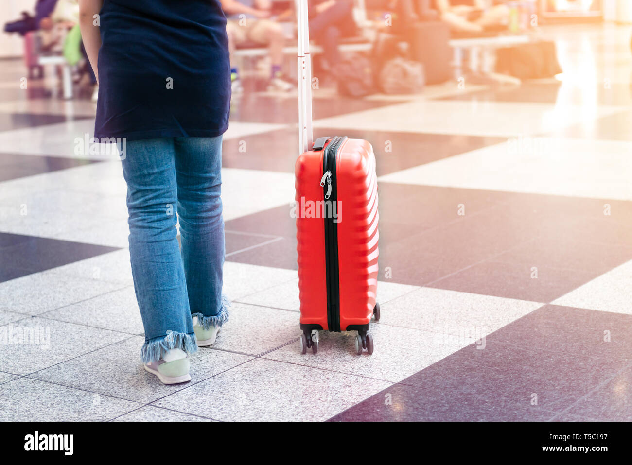 Chica está en el aeropuerto con el tamaño de la cabina luminoso y elegante  maletín como concepto de vacaciones Fotografía de stock - Alamy