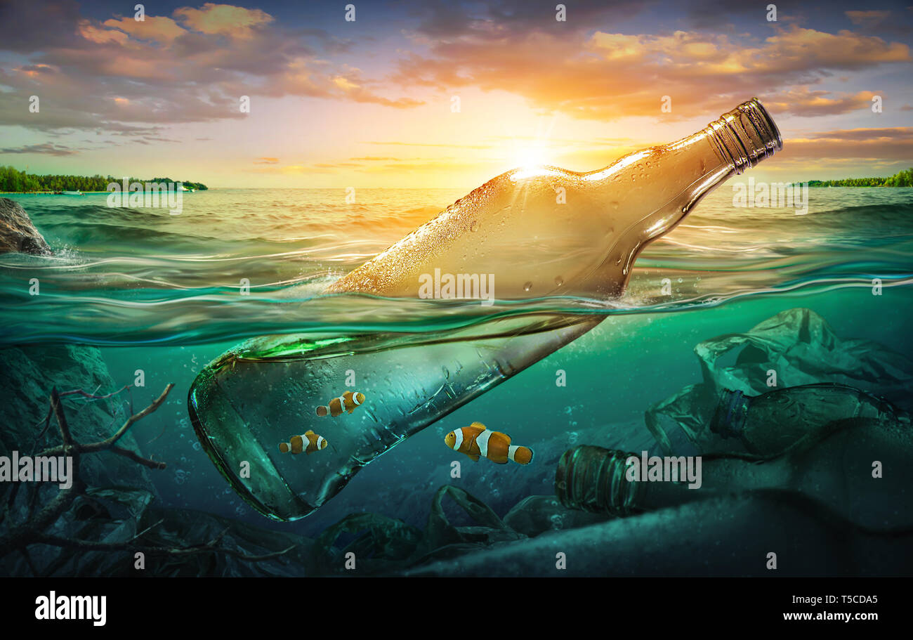 Peces pequeños en una botella entre la contaminación del océano. Concepto de entorno Foto de stock