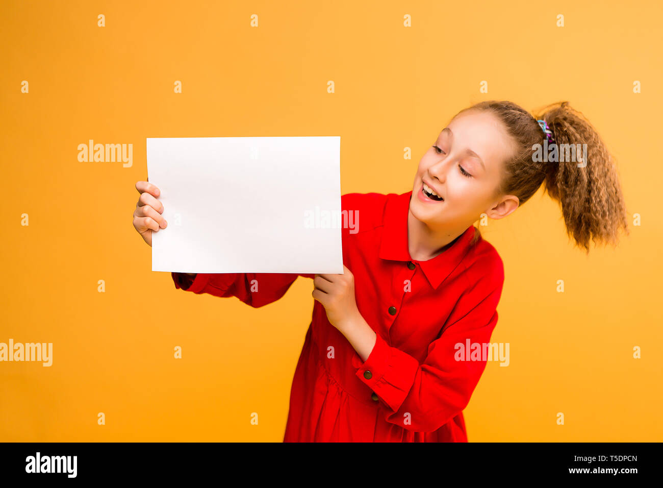 Chica sujetando la hoja blanca.cute little girl con la hoja blanca de
