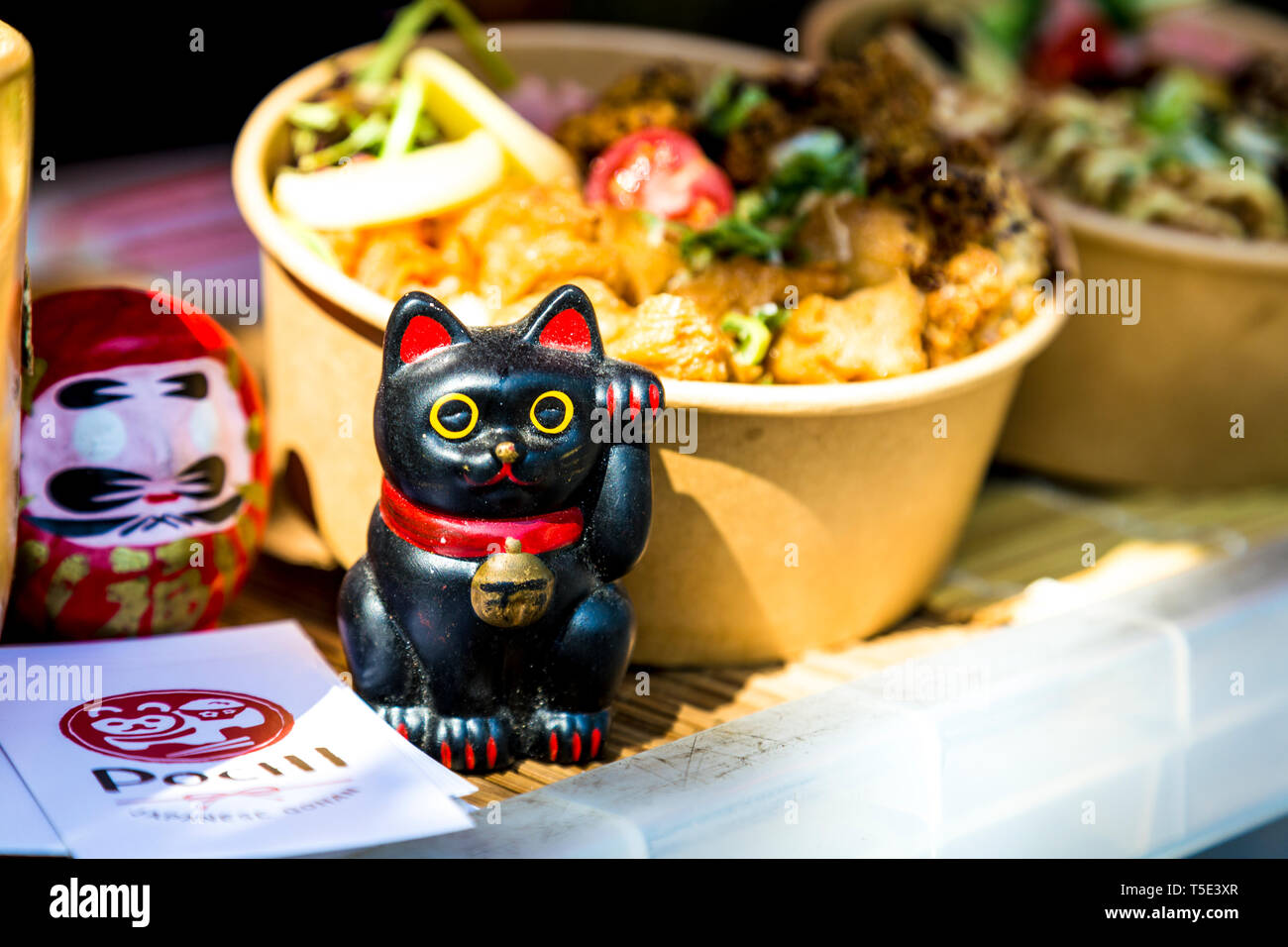 Lindo gato afortunado figurilla japonesa en la calle Pochi puesto de comida en el mercado de Victoria Park, Londres, Reino Unido. Foto de stock