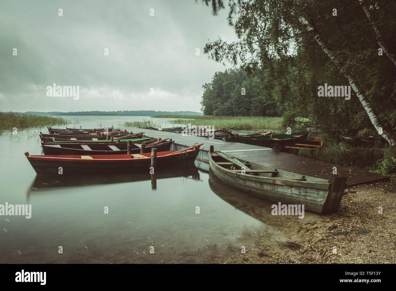 Barcos de madera sobre el lago durante la tormenta y el viento, la larga exposición, el lago Wigry, Polonia. Foto de stock