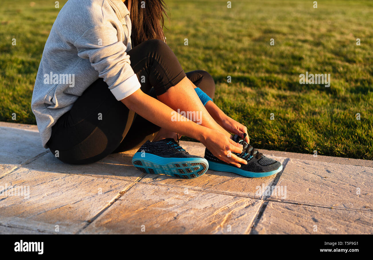 Mujer joven shoelace atado de zapatillas para hacer outwork ENTRENAMIENTO  RUNNING. Fitness y estilo de vida saludable Fotografía de stock - Alamy