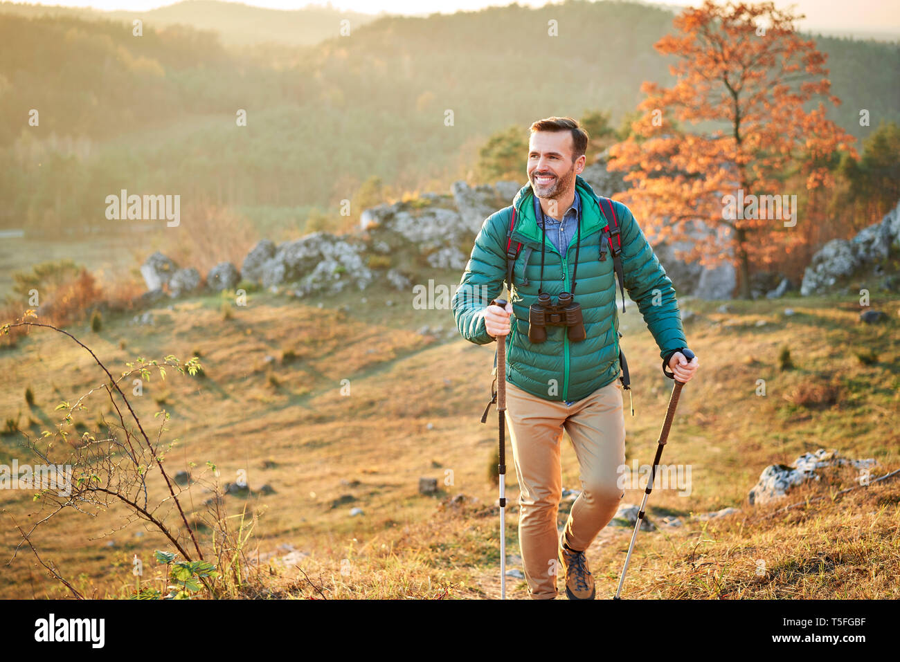 Feliz el hombre caminando en el camino en una excursión en las montañas Foto de stock