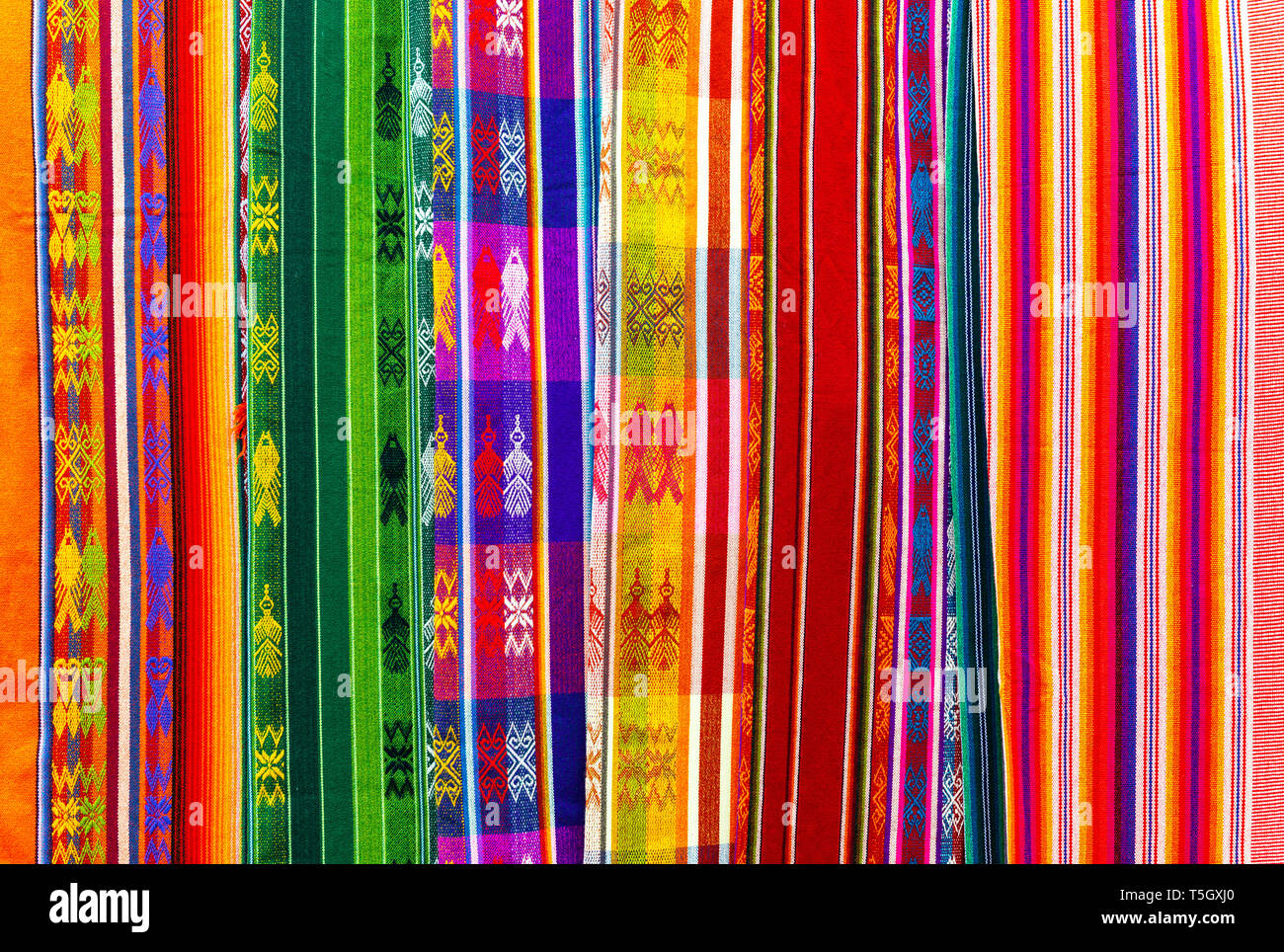 Andes coloridos textiles en el arte y el Mercado Artesanal de Otavalo, al norte de Quito, en Ecuador. Estas telas también se pueden encontrar en Perú y Bolivia. Foto de stock