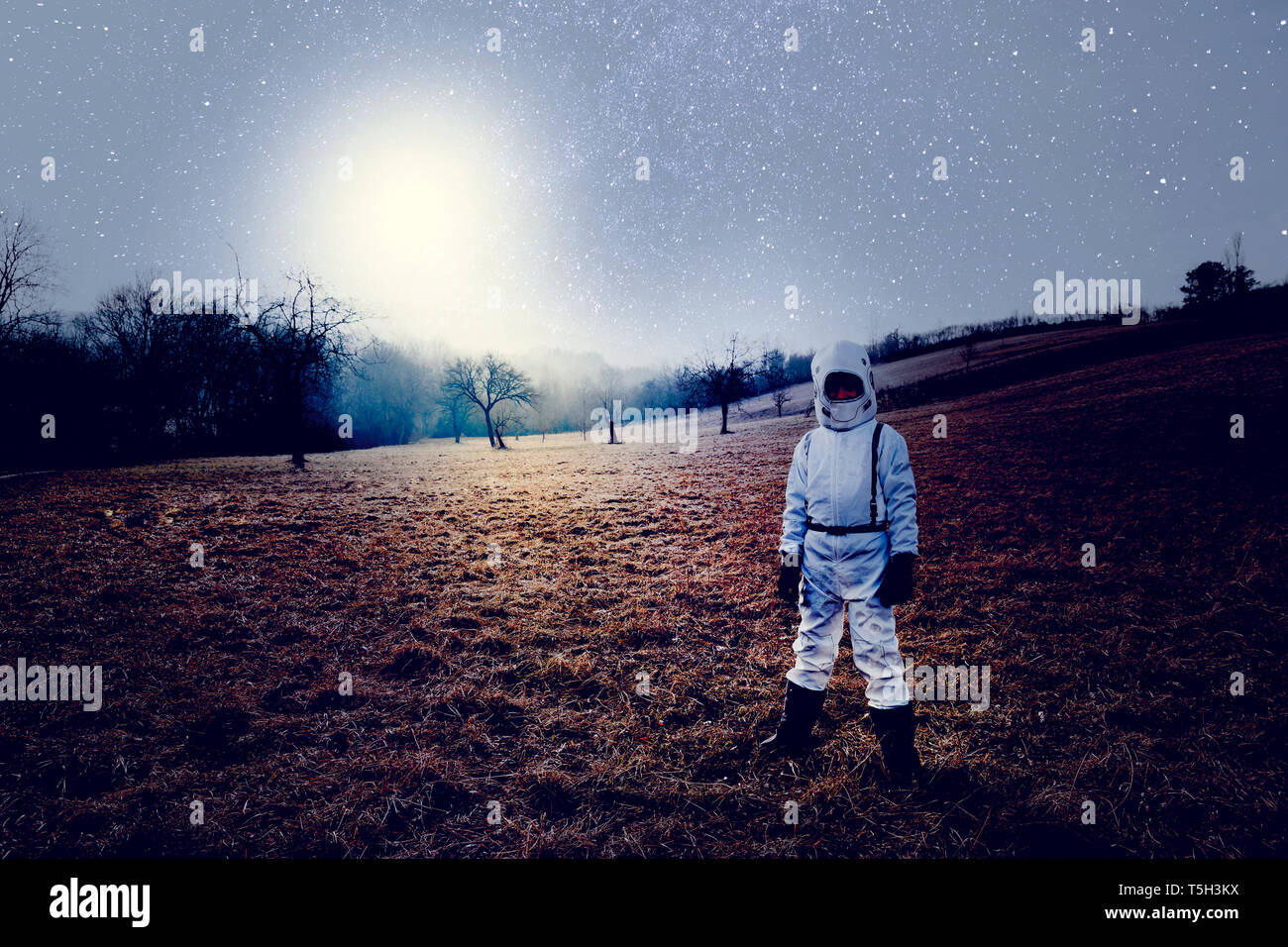 Boy vestidas de blanco traje espacial, el cielo estrellado. Foto de stock