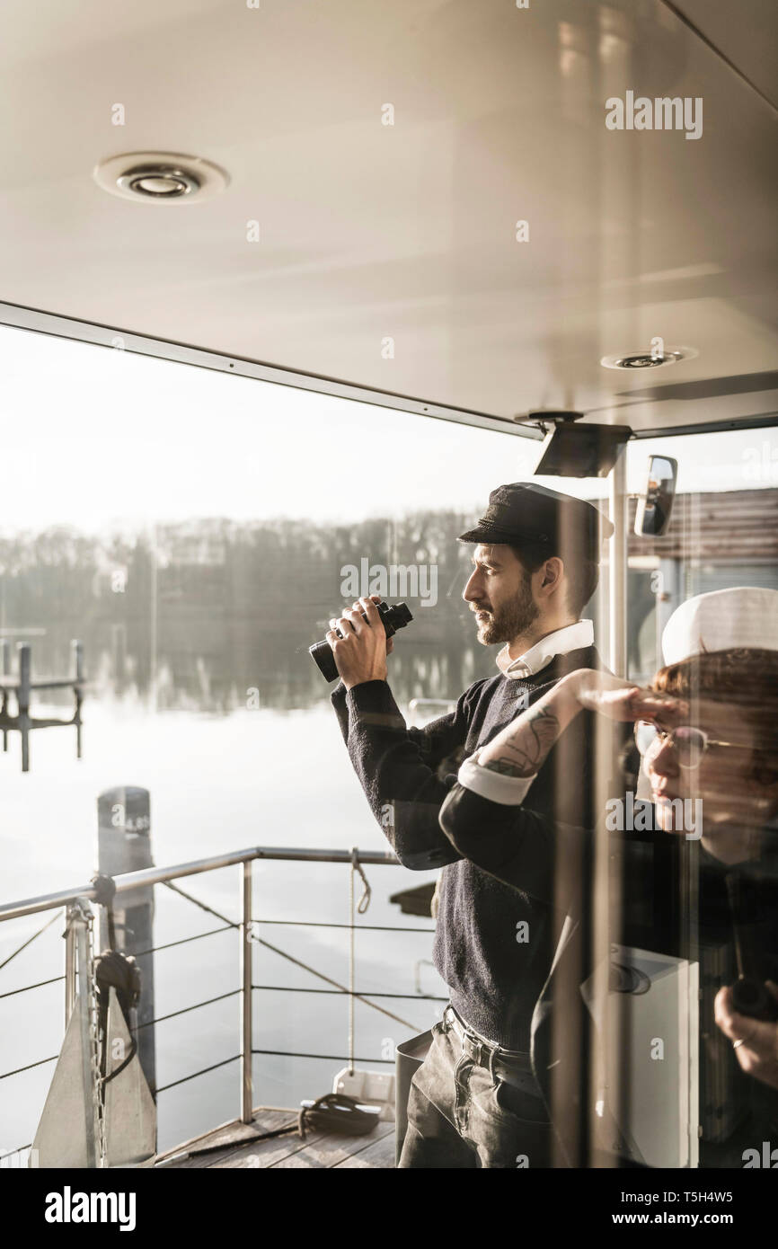 Los colegas que trabajan en un barco, mirando alrededor con prismáticos Foto de stock