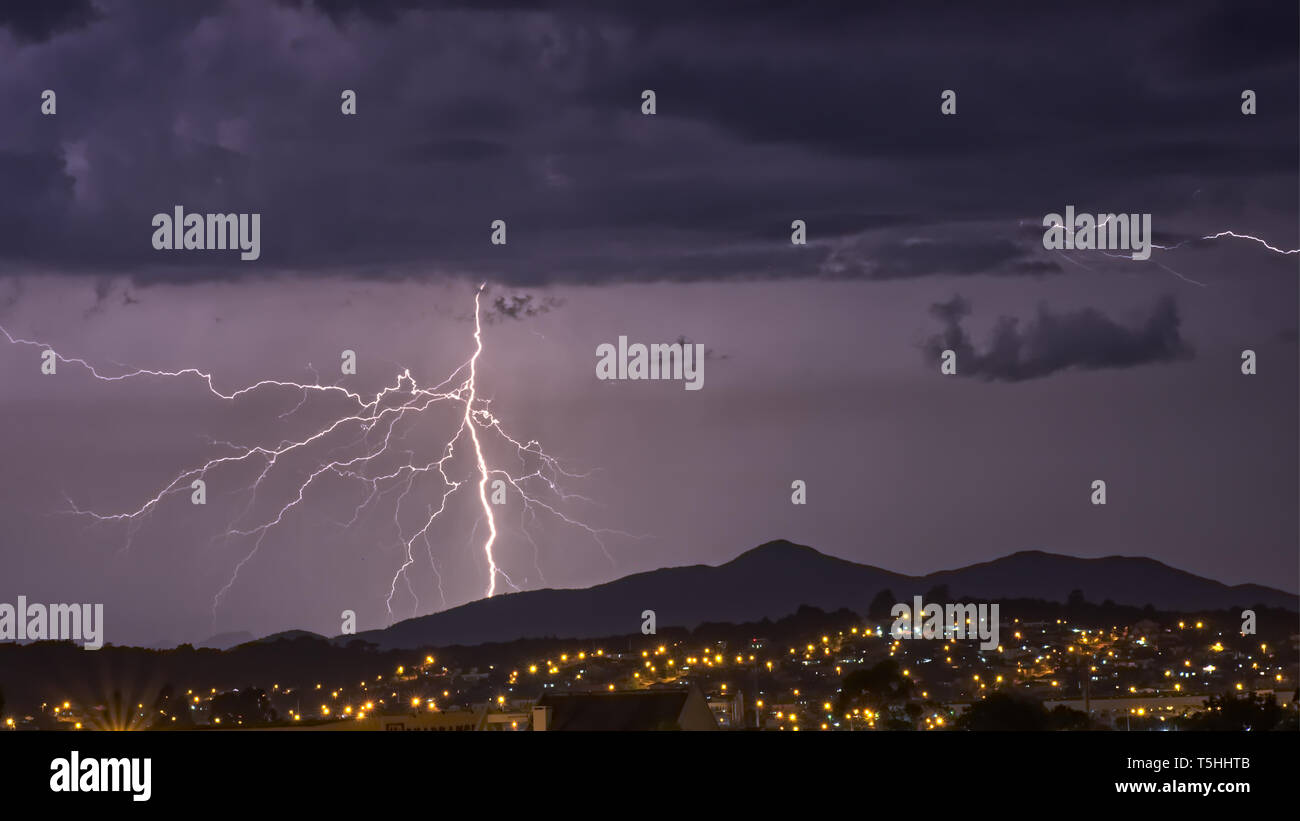 Poderosa tormenta eléctrica en el morado oscuro cielo de la ciudad de Pinhais, Paraná, Brasil Foto de stock
