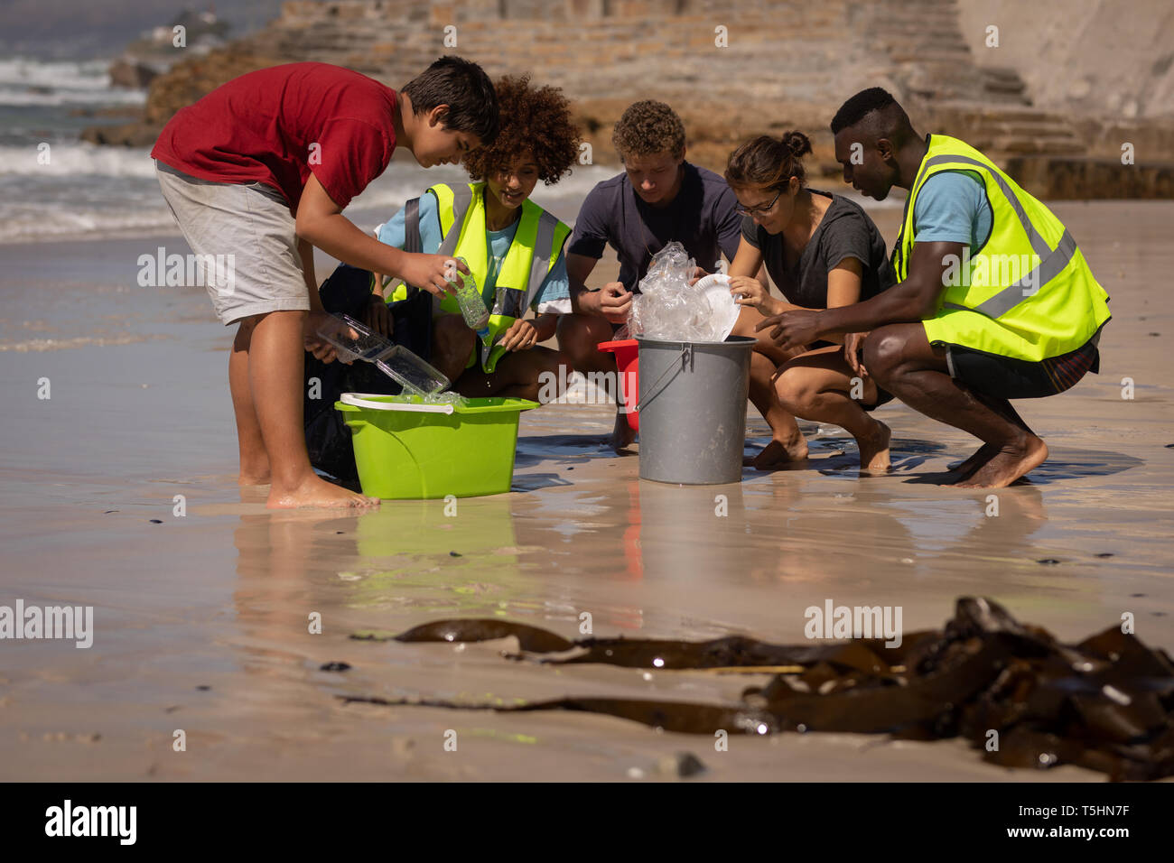 Los voluntarios de limpieza en un día soleado de playa Foto de stock