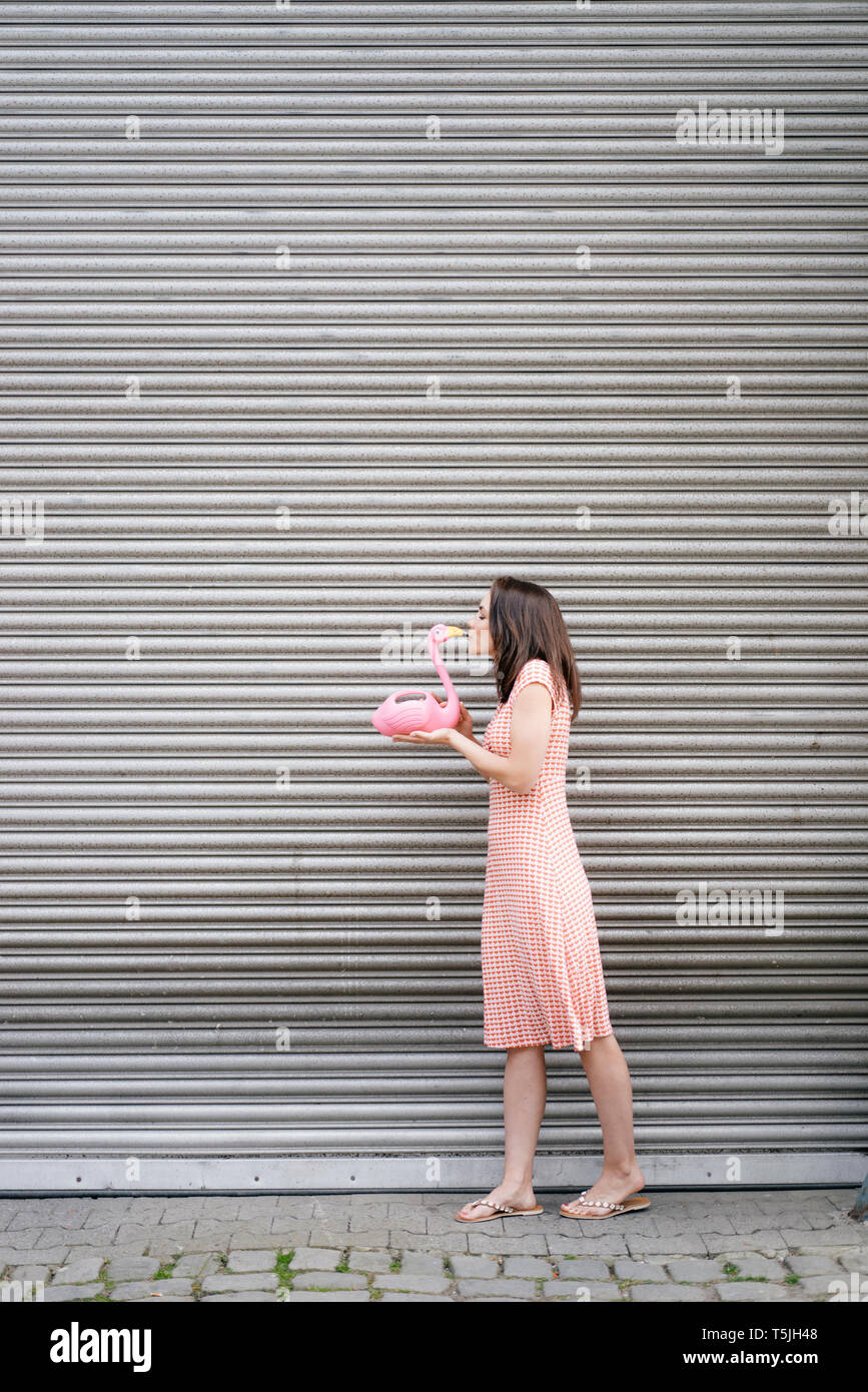 Mujer en ropa de verano con corazón patrón, kkissing pink flamingo figura  Fotografía de stock - Alamy