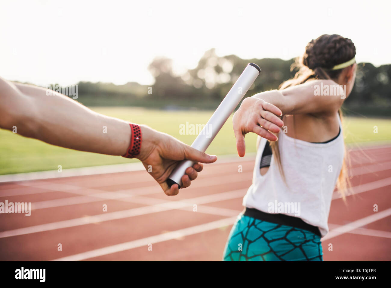 Close-up de un atleta de pasar el relevo a un atleta femenina Foto de stock