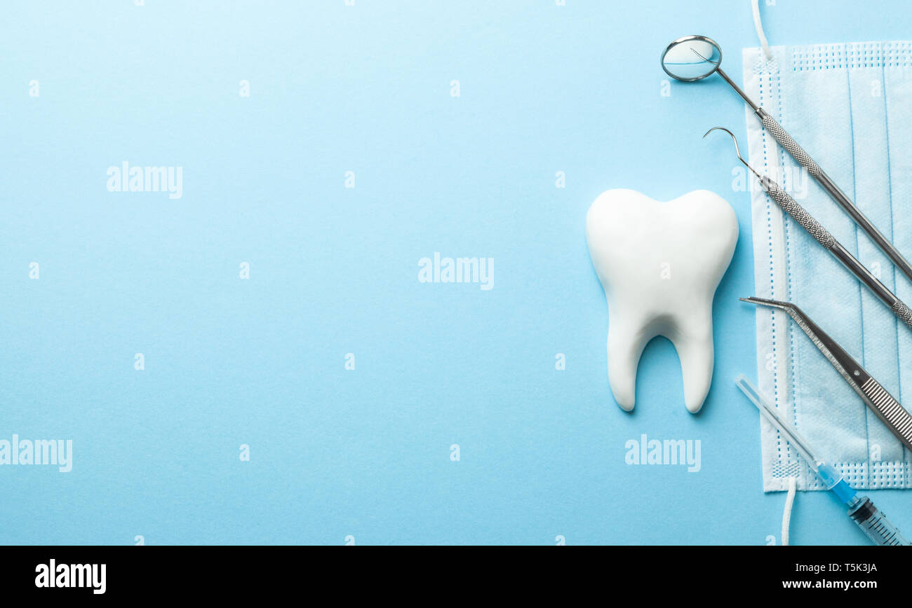 Instrumentos Dentales Y Dientes Sobre Fondo Azul Tratamiento Dental Herramientas De Dentista Espejo Pinzas De Gancho Jeringa Espacio Para El Texto Copia Fotografia De Stock Alamy