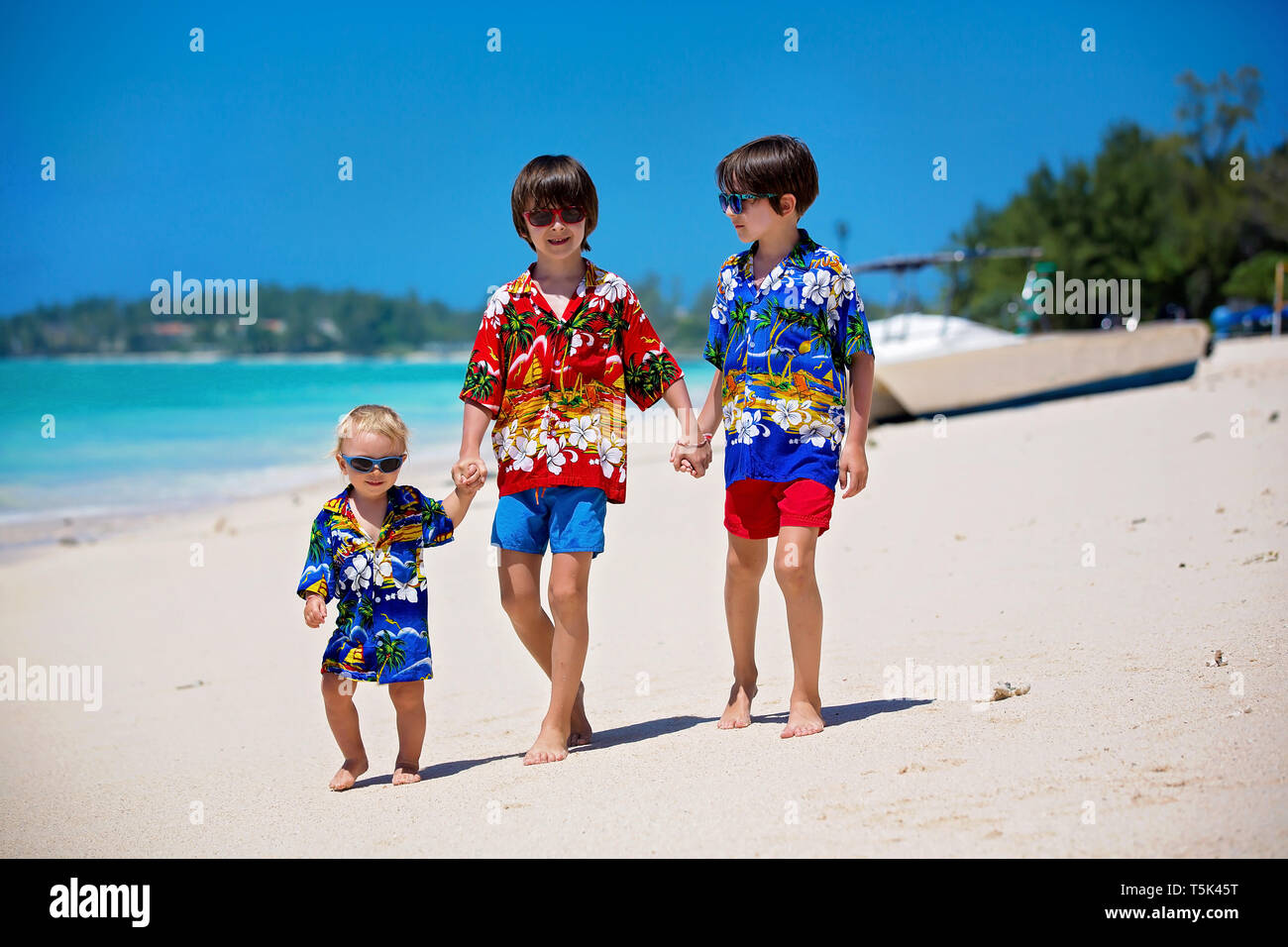 Felices los Niños Moda hermosos, vestidos con camisetas hawaianas, jugando  juntos en la playa, familia feliz vacaciones Fotografía de stock - Alamy