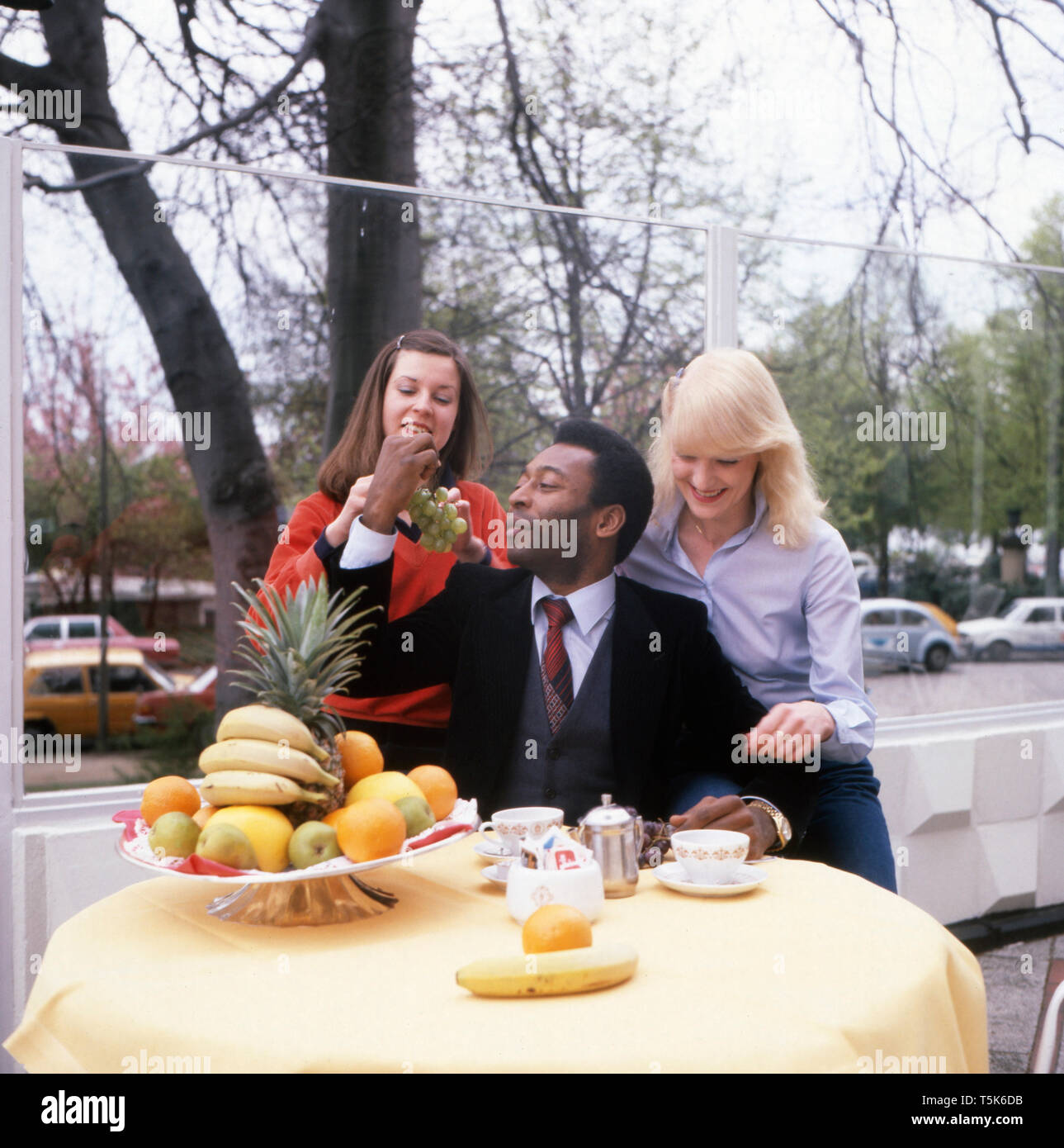 Die Fußballlegende Pele frühstückt zusammen mit zwei jungen Frauen, Deutschland 1981. La leyenda del fútbol, Pele, está desayunando junto con dos jóvenes, Alemania 1981. Foto de stock