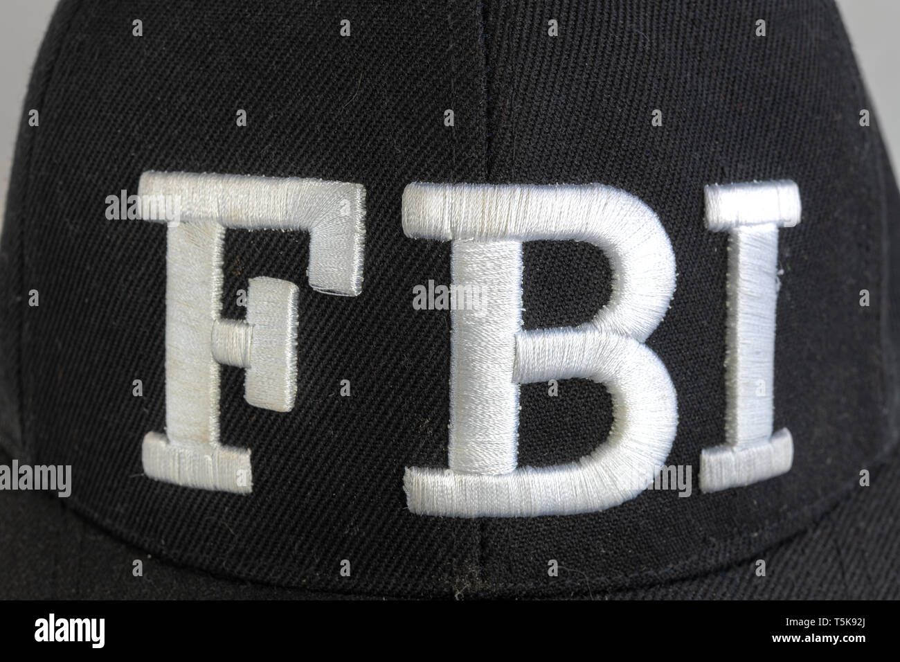 Cerca del logotipo del FBI sobre un gorro negro. El texto actual de la Oficina Federal de Investigaciones. Vista frontal. Foto de stock