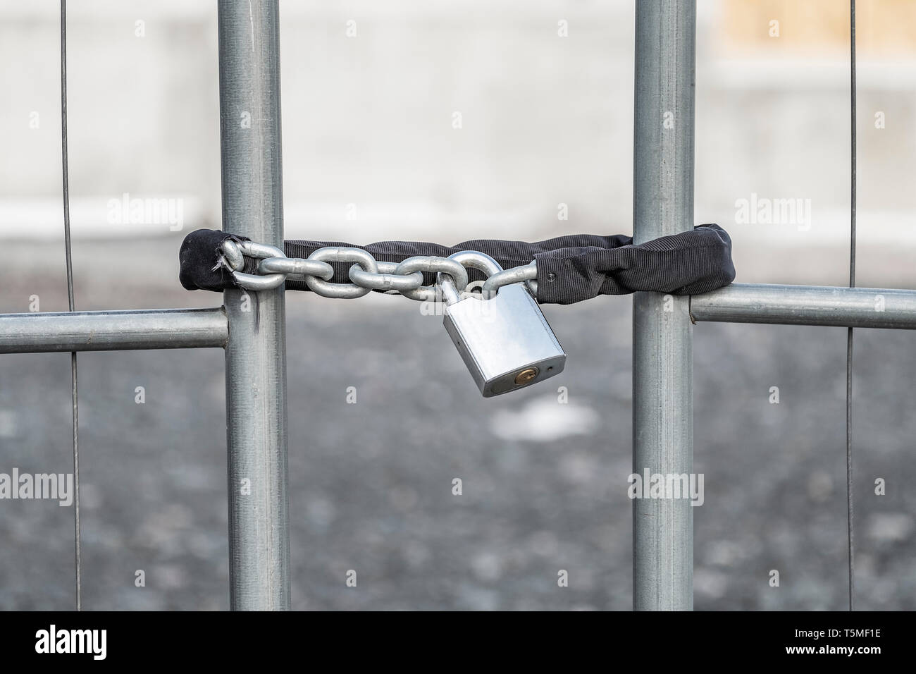 Un candado con cadena que fijan la puerta a un sitio en construcción. Foto de stock