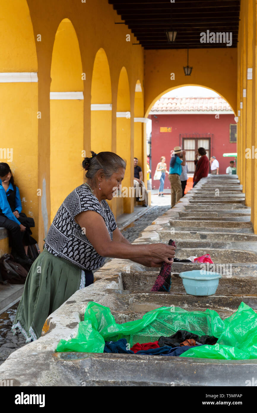 Estilo de vida: Guatemala Guatemala Local mujer lavando ropa en el antiguo lavadero exterior tradicional, Antigua, Guatemala, América Central Foto de stock