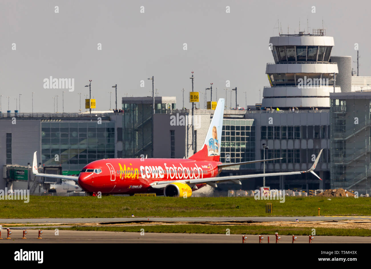 El Aeropuerto Internacional de Dusseldorf, DHE, avión TUIFly, Boeing 737-8K5 en la pista de rodaje, la torre de control del tráfico aéreo, en el edificio de la terminal, con especial pai Foto de stock