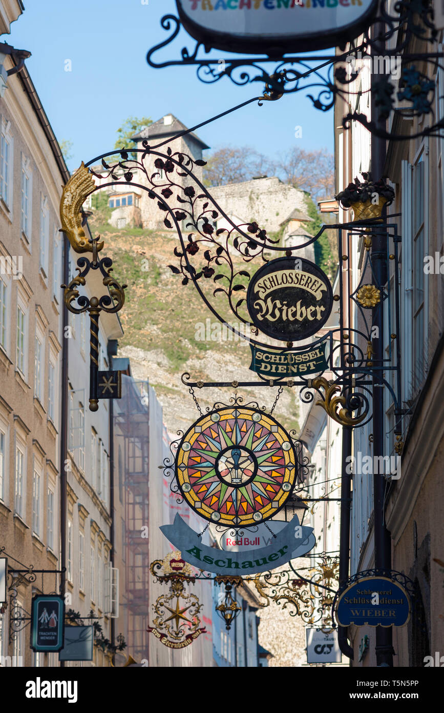 Salzburgo Getreidegasse, la vista de los letreros de las tiendas en la calle Getreidegasse, la calle más larga y más concurrida en la zona del casco antiguo de Salzburgo, Austria. Foto de stock