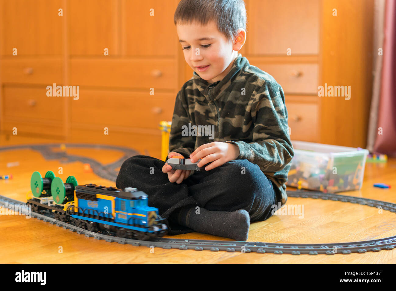 Niño Jugando Con Un Tren De Juguete Chico Jugando Con El Ferrocarril Acostado En El Piso 