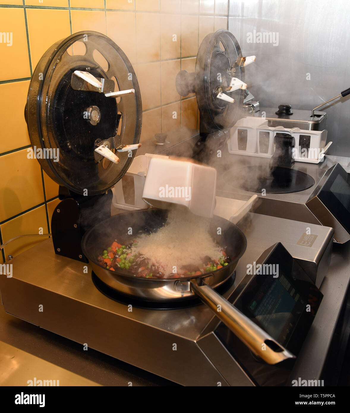 En Dusseldorf, Alemania. 26 abr, 2019. Robots de cocina están de pie en la  China snack bar 'Ai Wok'. Quienes comen aquí no ve un cocinero, porque aquí  cuatro robots cocinar para