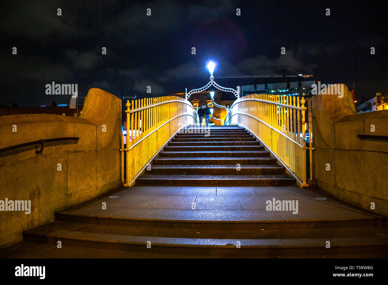 Dublín, Irlanda - Marzo de 2019. El popular Ha'Penny Bridge de noche sobre el río Liffey en Dublín. Foto de stock