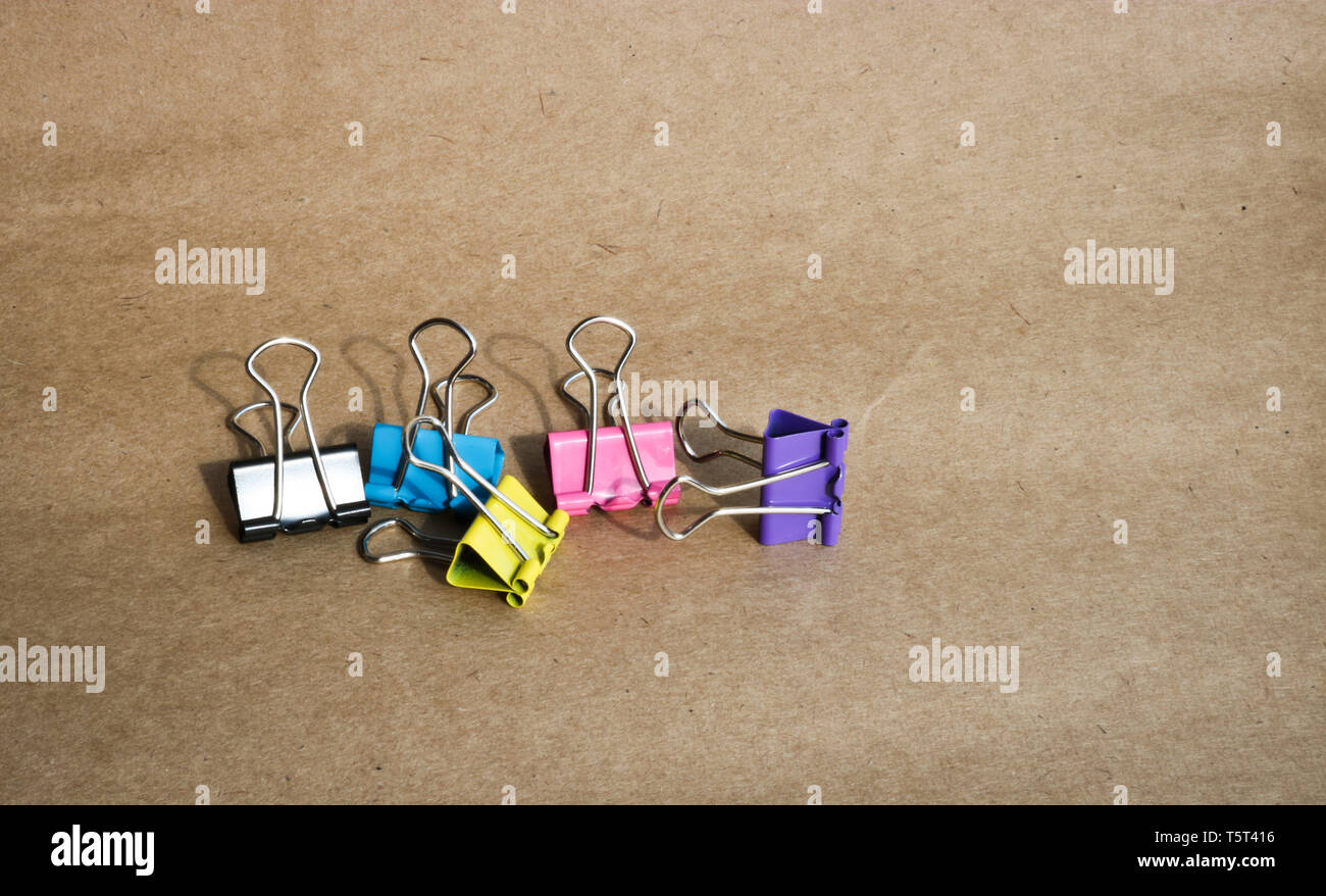 Clips para papel de diferentes colores en el fondo de papel kraft