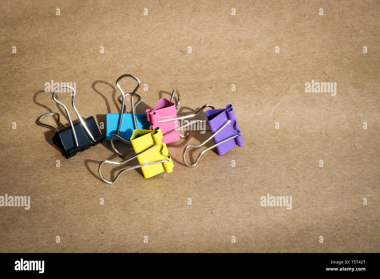 Clips para papel de diferentes colores en el fondo de papel kraft
