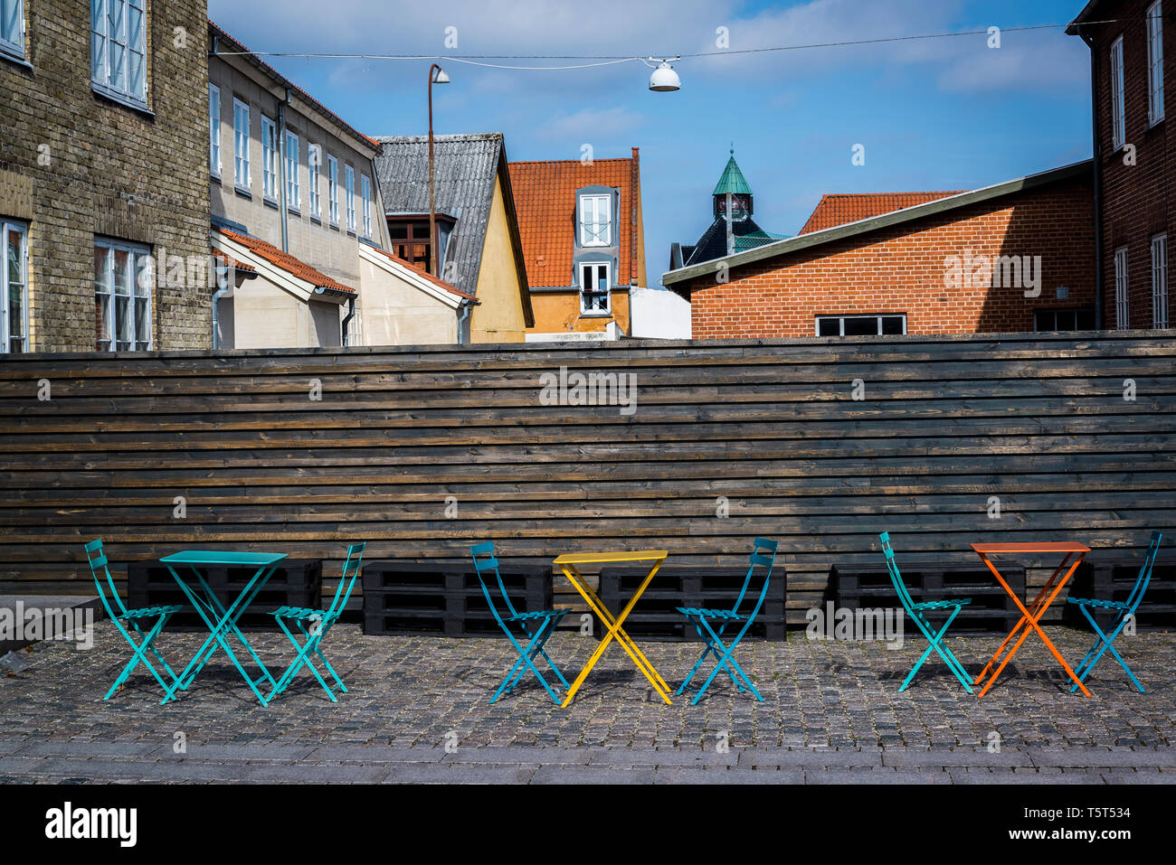 Pintado de colores vivos mesas y sillas en un café al aire libre, Roskilde, Dinamarca Foto de stock
