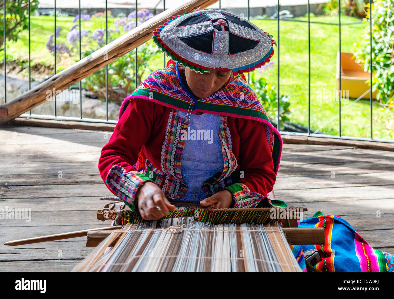 Una mujer indígena Quechua, mostrando la técnica de tejido y la fabricación de textiles en la cordillera de Los Andes de América del Sur en Cusco, Perú. Foto de stock