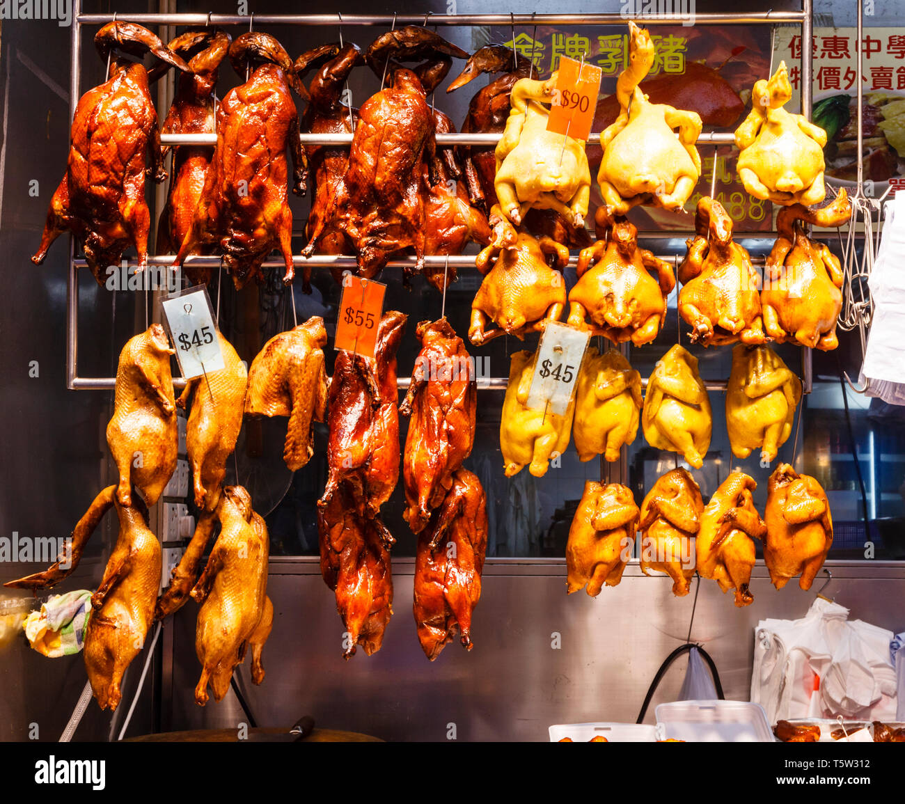 Pato cocido y pollo colgando en una tienda de carnicero en el distrito de Wan Chai en la isla de Hong Kong, Hong Kong Foto de stock