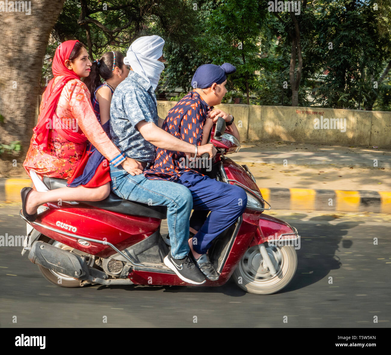 Familia de cuatro en un motor scooter a través de Nueva Deli en el norte de la India. Foto de stock