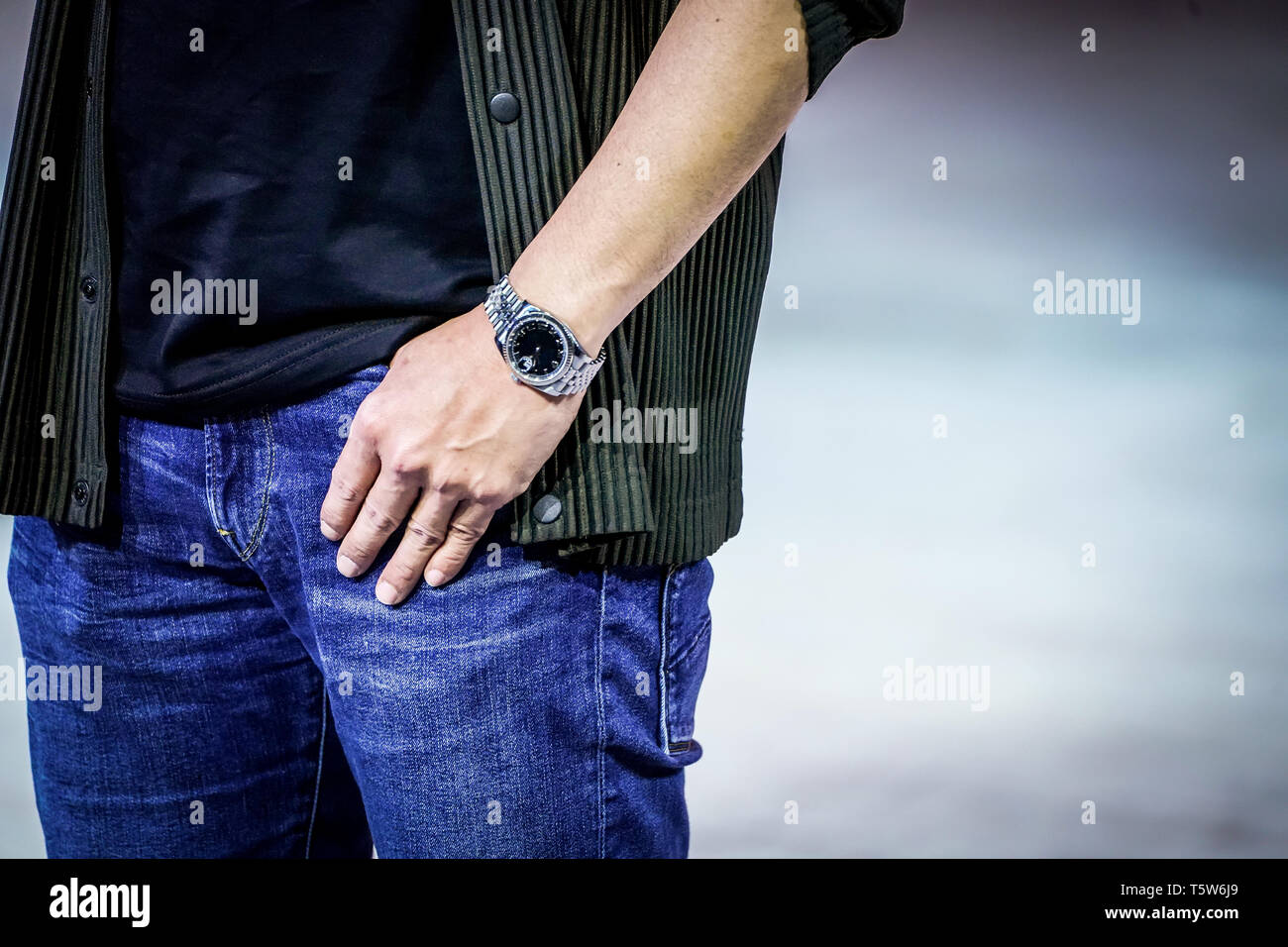 Hombre inteligente posa con su reloj, traje y jean. Cierre en su mano y  observar Fotografía de stock - Alamy