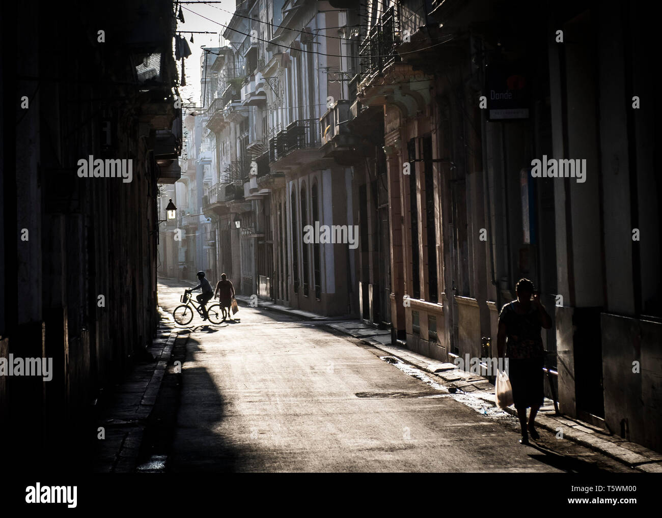 Los cubanos jefe para trabajar como el sol brilla a través de las calles de La Habana, Cuba Foto de stock