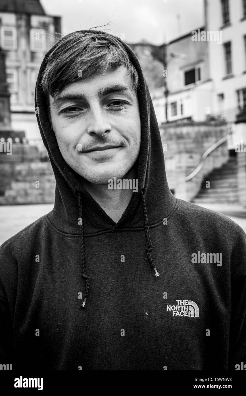 Un joven hombre vestido con una sudadera con capucha plantea en su ciudad  natal. Y la gente de la calle Chepstow Fotografía de stock - Alamy