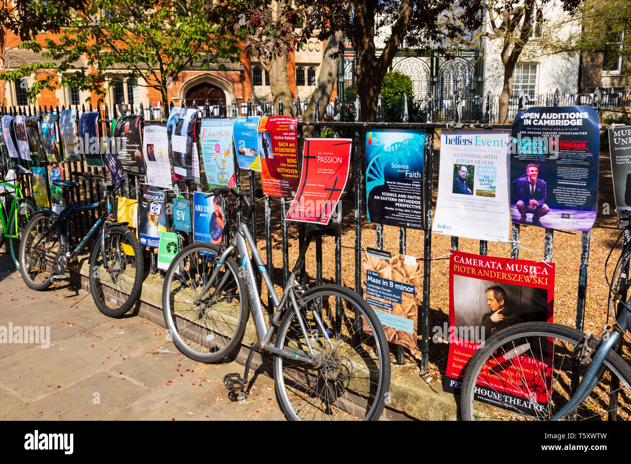 Las bicicletas y los carteles en las rejas del jardín de todos los santos, el arte y la feria de artesanía, Trinity Street, ciudad universitaria de Cambridge, Cambridgeshire, Engla Foto de stock