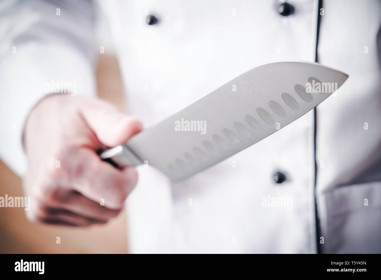 Chef de cocina con un gran cuchillo afilado en una mano. La preparación de las comidas. Foto de stock