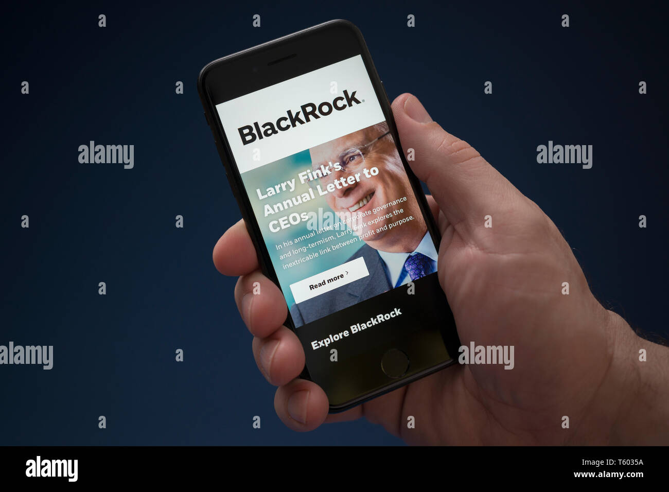 Un hombre mira el iPhone que muestra el logotipo de BlackRock (uso Editorial solamente). Foto de stock
