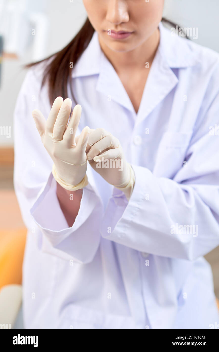 Dentista poniendo en professional guantes de goma Foto de stock