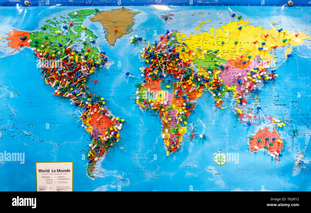 Chinchetas marcando las ubicaciones en un mapa del mundo. Foto de stock