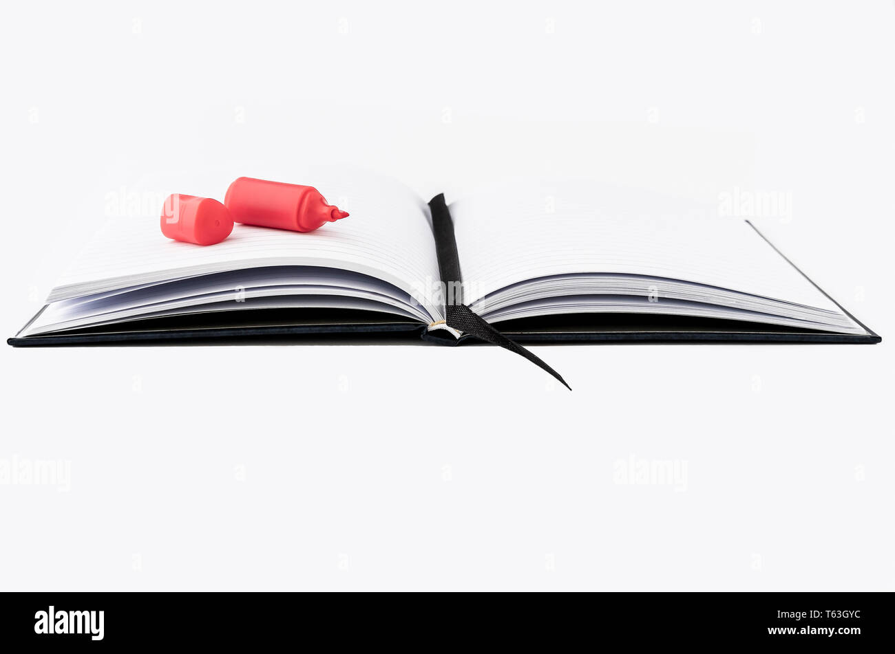 Tomar notas, una página aislada del libro con una pluma de resaltado en rojo sobre fondo blanco. Foto de stock