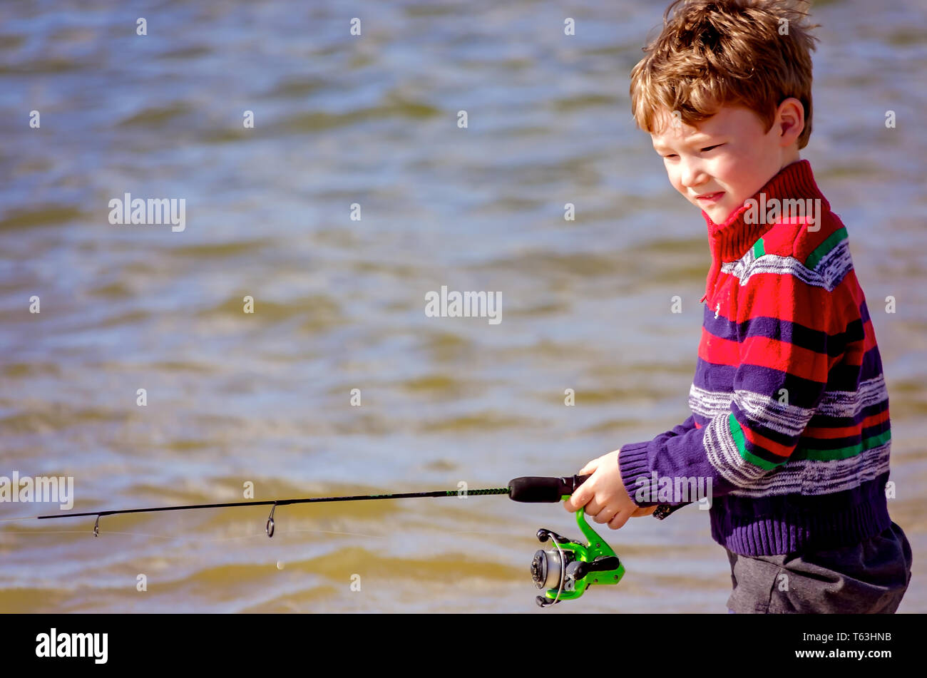 Un niño pesca con un carrete spinning, 14 de abril de 2019, en Bayou La Batre, Alabama. Foto de stock