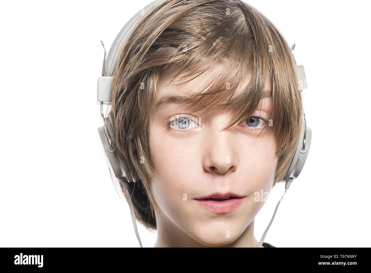 Cute sonriente joven muchacho con auriculares, aislado en blanco Foto de stock