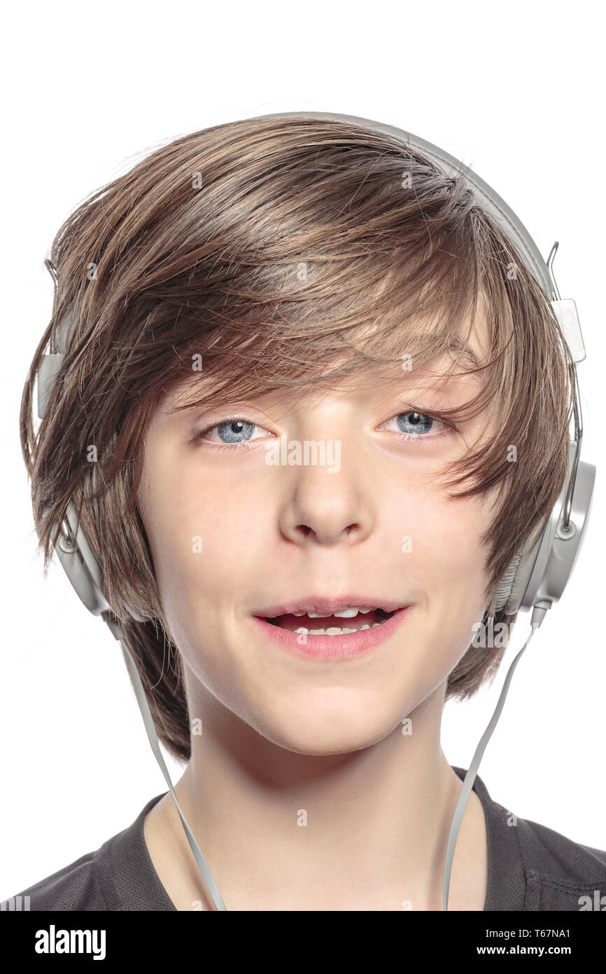 Cute sonriente joven muchacho con auriculares, aislado en blanco Foto de stock