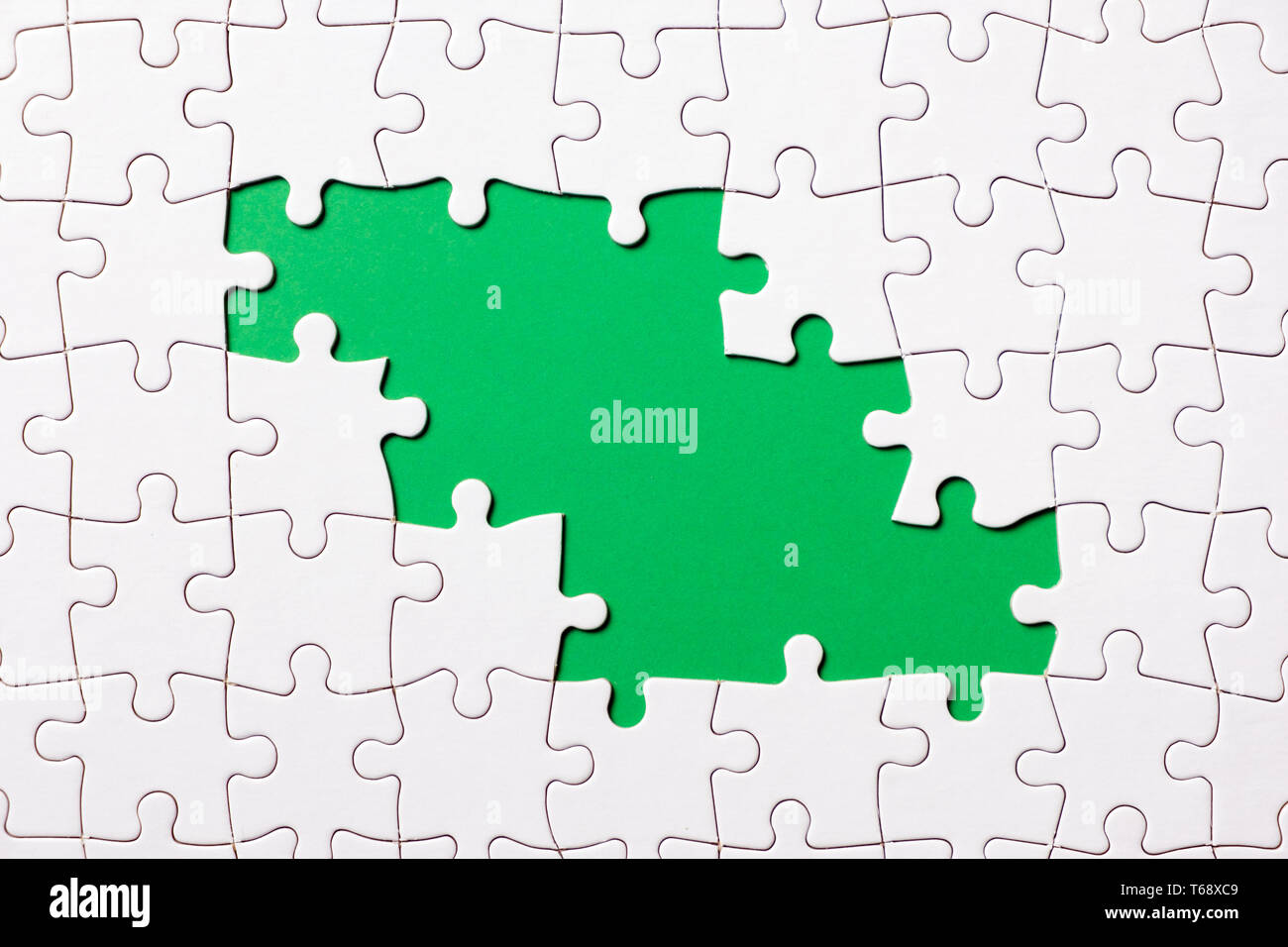 Jigsaw Puzzle pieza sobre fondo verde para el tema del diseño de negocios Foto de stock