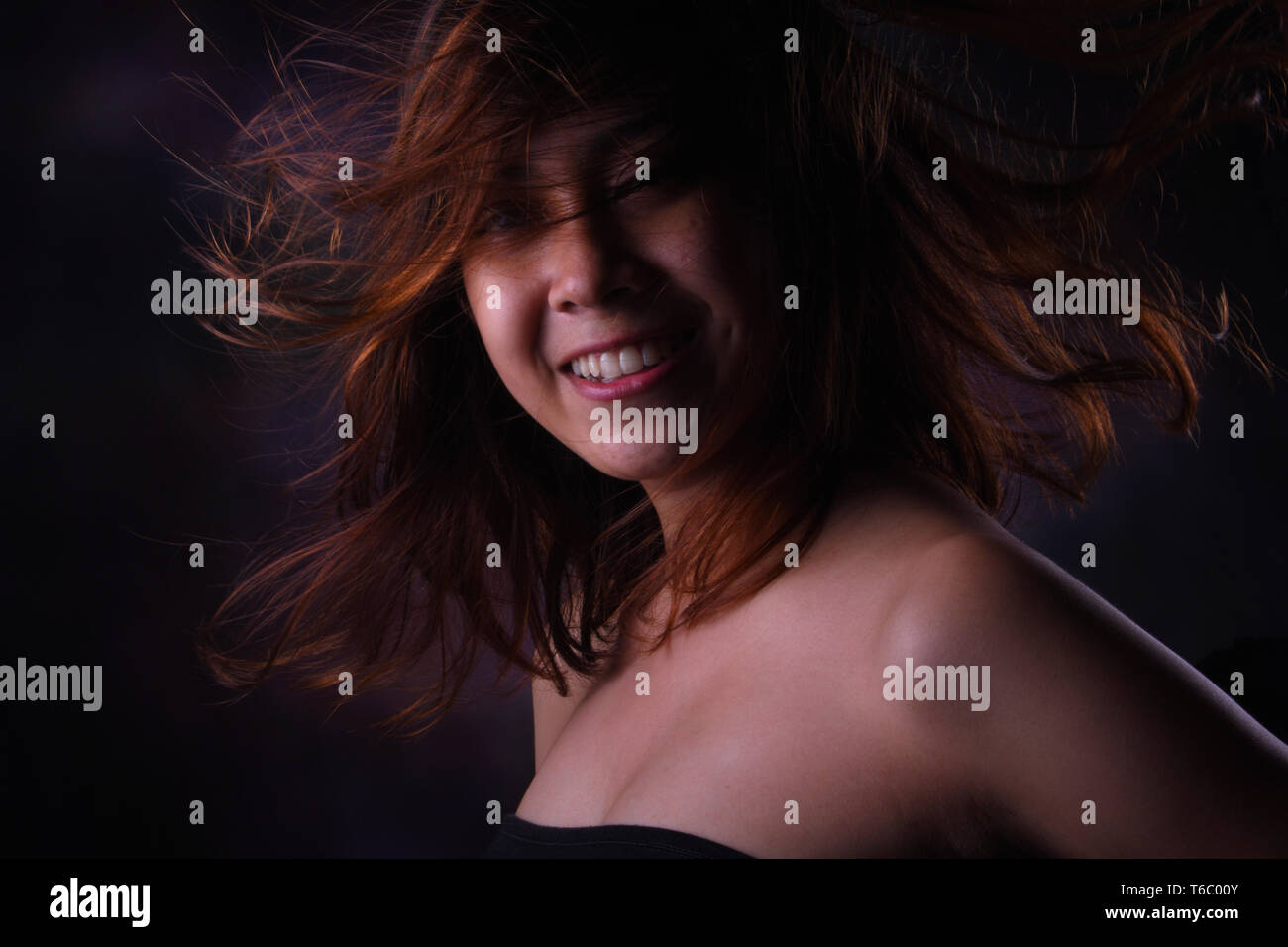 Smilling mujer, pelo rubio con poca luz studio Foto de stock
