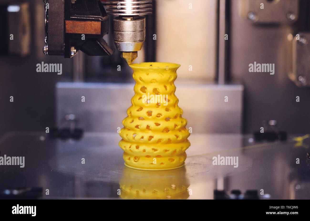 Impresora 3D imprime desde el plástico figura closeup. La impresora 3D  Modelo amarillo hace cerca en una superficie plana gris Fotografía de stock  - Alamy