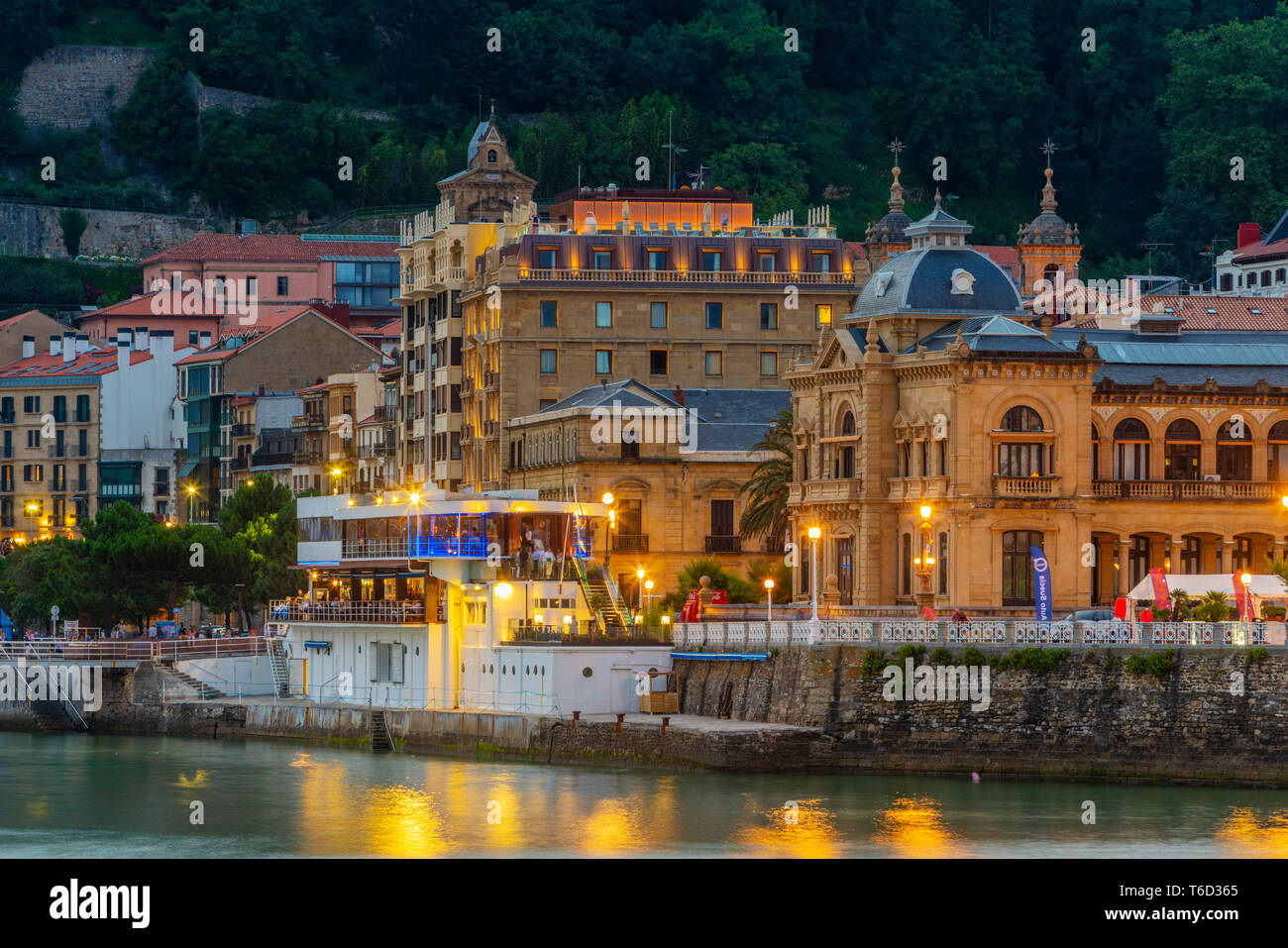 España, País Vasco, San Sebastián (Donostia), el Ayuntamiento y el casco antiguo de la ciudad iluminada por la noche Foto de stock