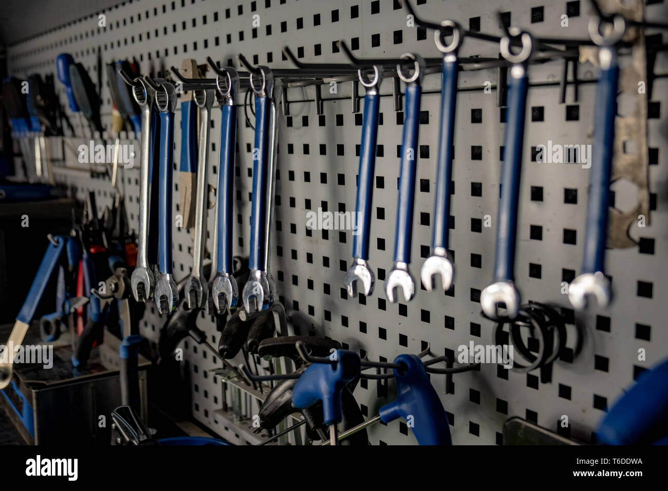 El taller del reparador, cerca bajo clave de imagen. Lugar de trabajo bien organizado de un mecánico, filas de llaves de tuercas y otras herramientas, Vista cercana Foto de stock